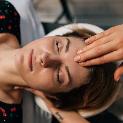 Relaxed person receiving gentle head touch